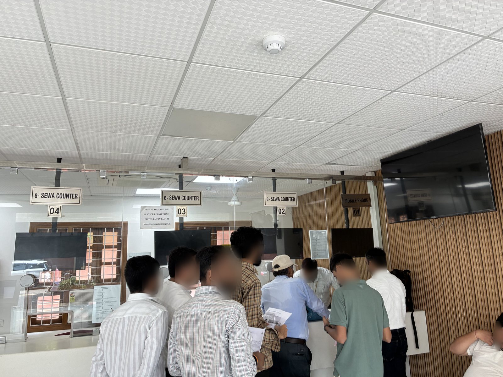 e-Sewa Kendraの窓口に並ぶ人々。MOBILE PHONEと書かれた窓口も見える