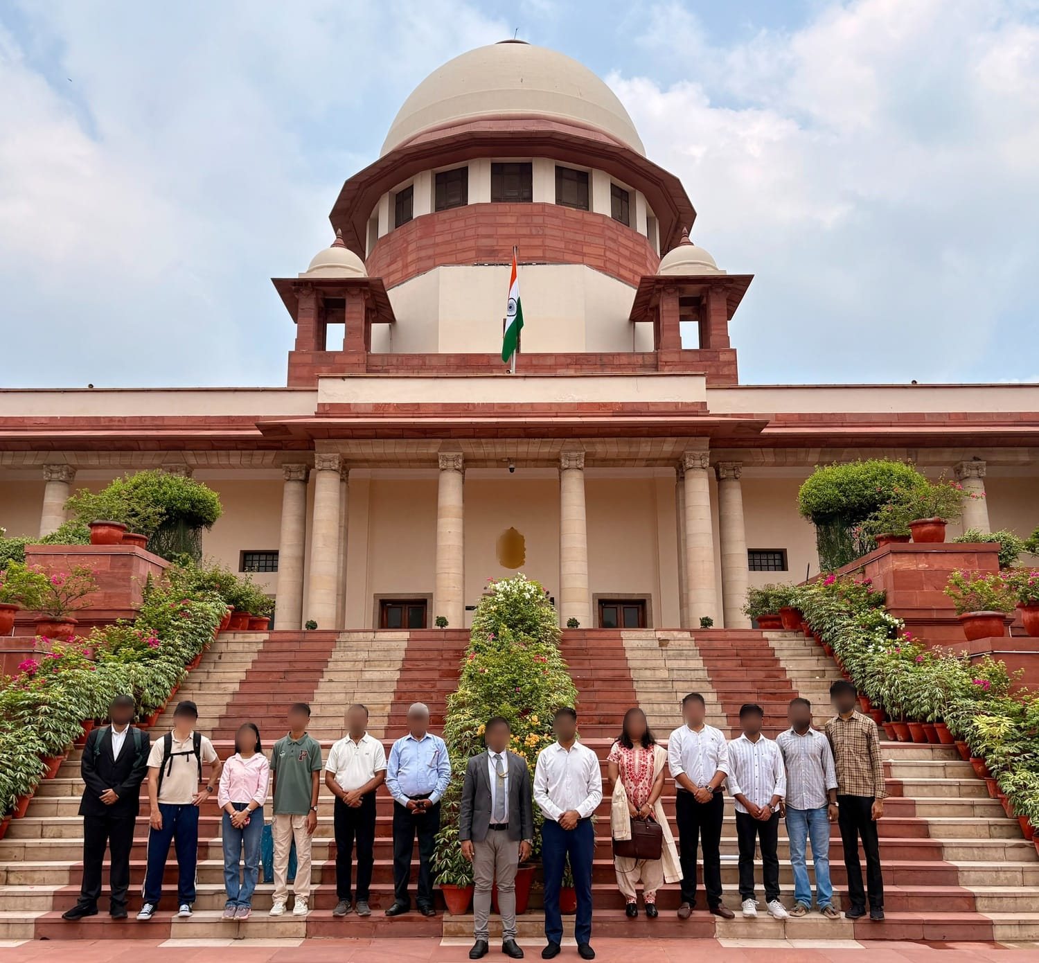 インド最高裁判所の正面階段でのガイドツアー参加者の記念写真