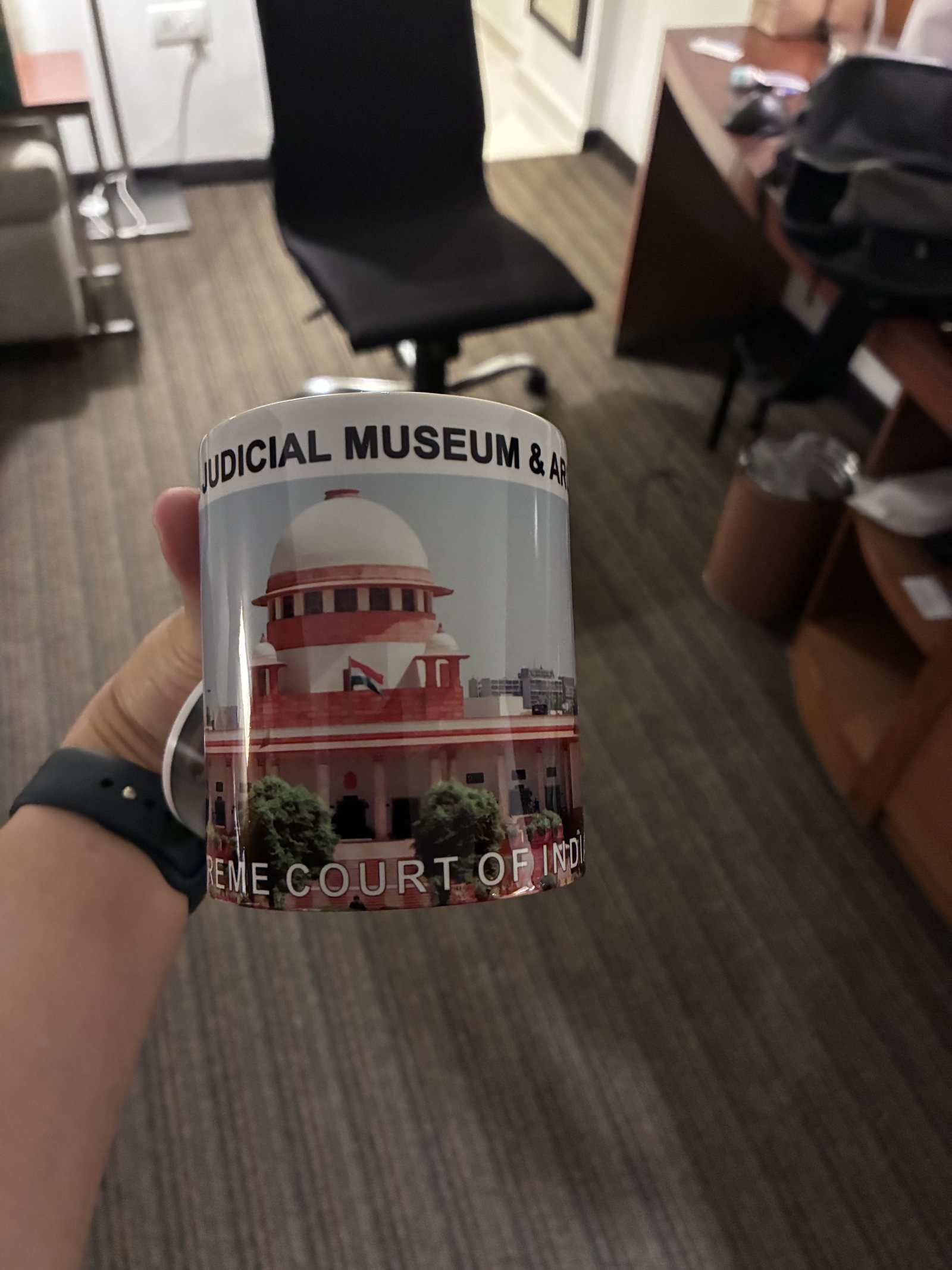 インド最高裁の記念品のマグカップ。National Judicial Museum & Archives と最高裁の建物が描かれている