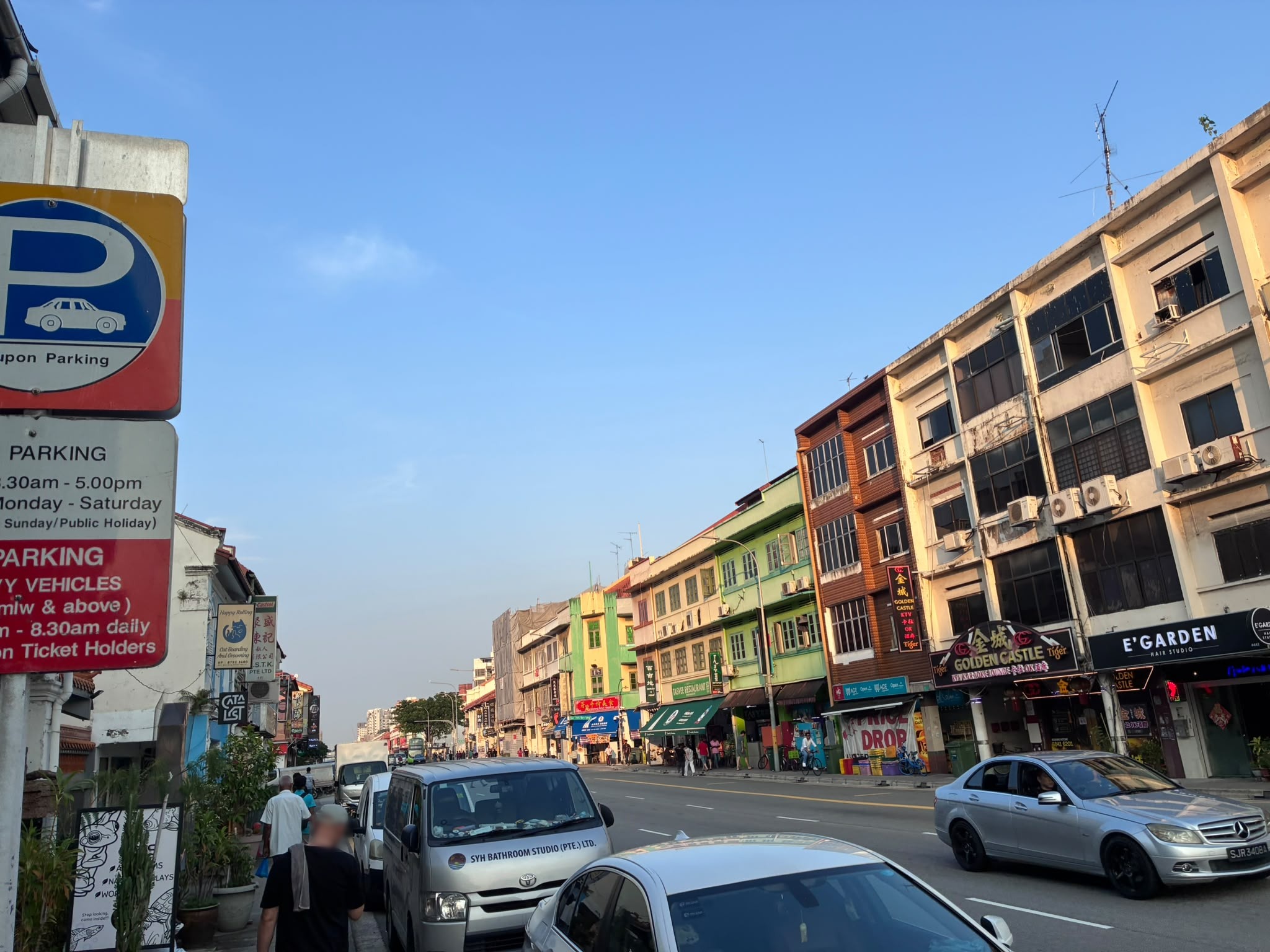 Colourful conserved shophouses along Geylang Road with KTV signs (faces blurred)