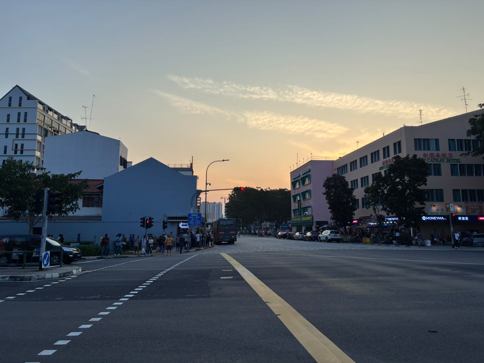 Geylang Road at sunset with New Cathay Hotel and moneychanger signs