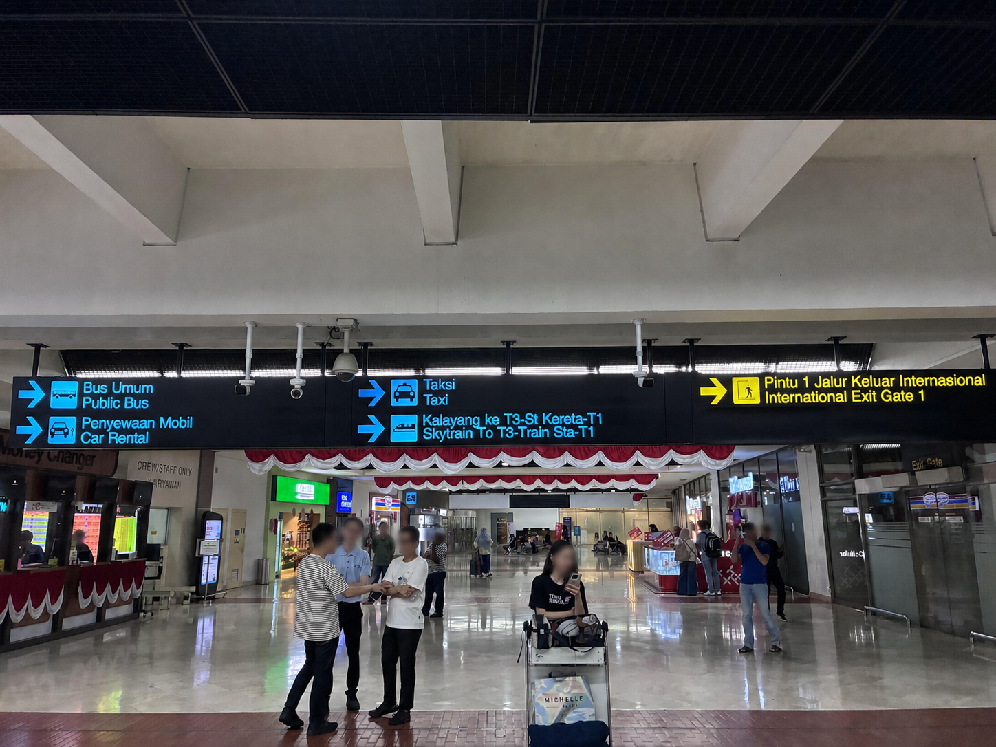 スカルノハッタ国際空港の出口と交通機関への案内表示（人物の顔をぼかし済み）
