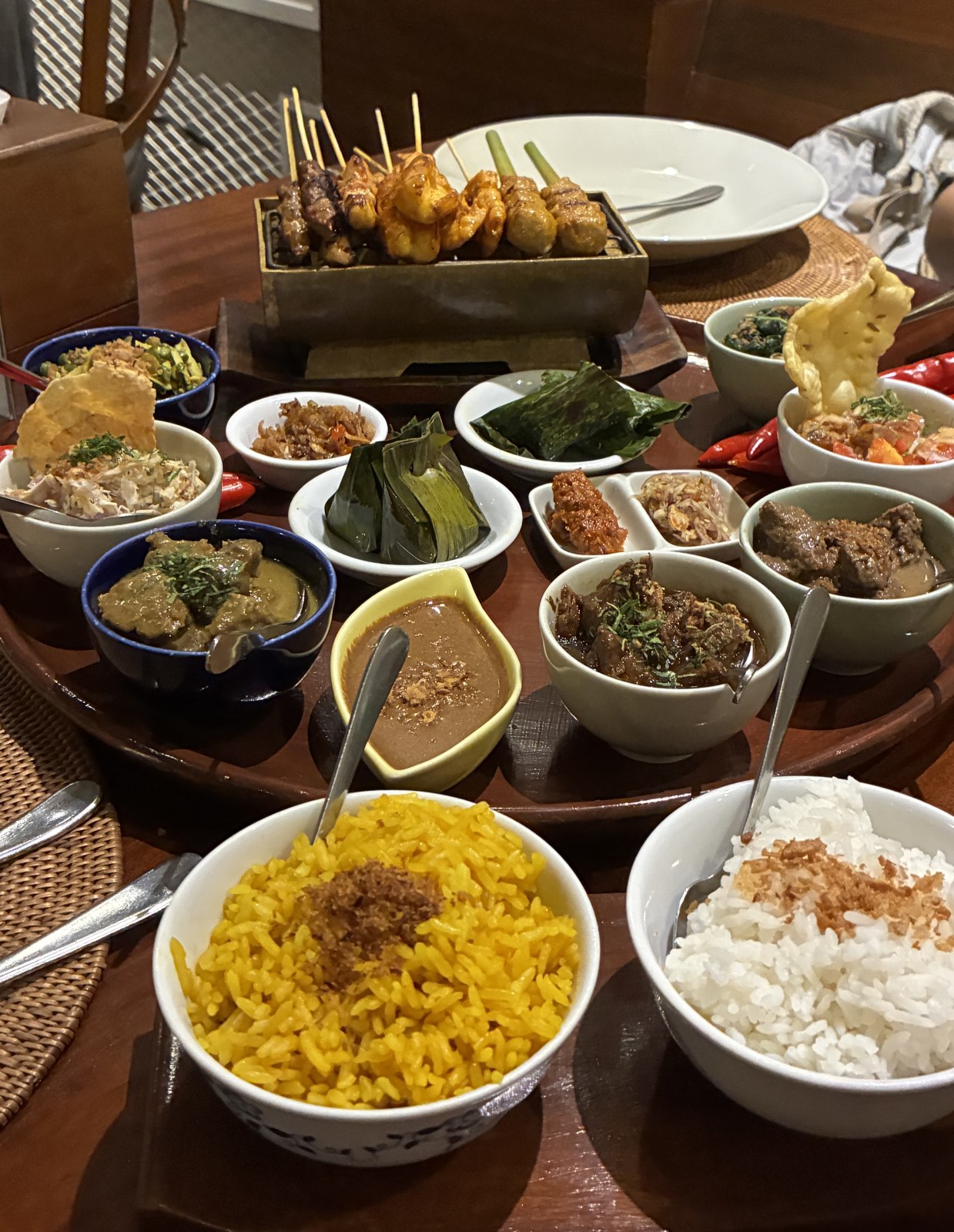 Balinese rijsttafel with satay skewers, yellow rice, white rice and many small dishes at Bumbu Bali, Indonesia