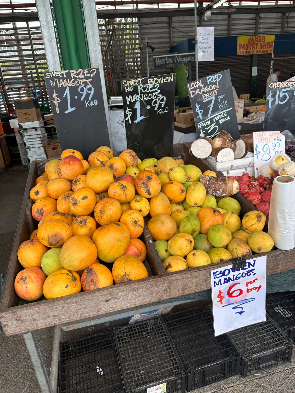 Bowen mangoes and dragon fruit with chalkboard prices at Rusty's Markets, Cairns