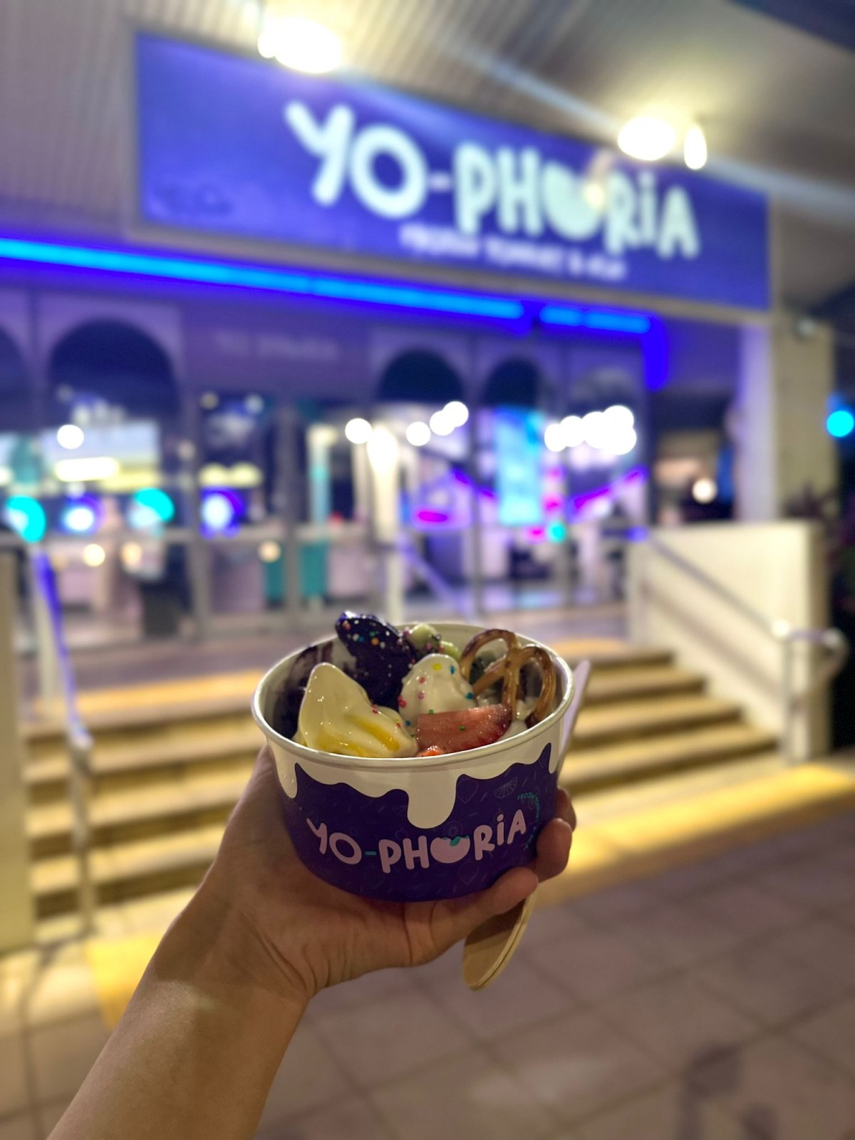Cup of self-serve frozen yogurt in front of the Yo-Phoria store in Cairns at night