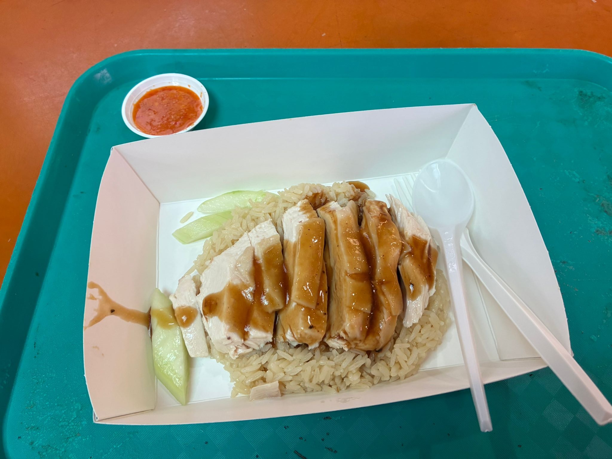 Hainanese chicken rice on a tray with chilli sauce at Maxwell Food Centre