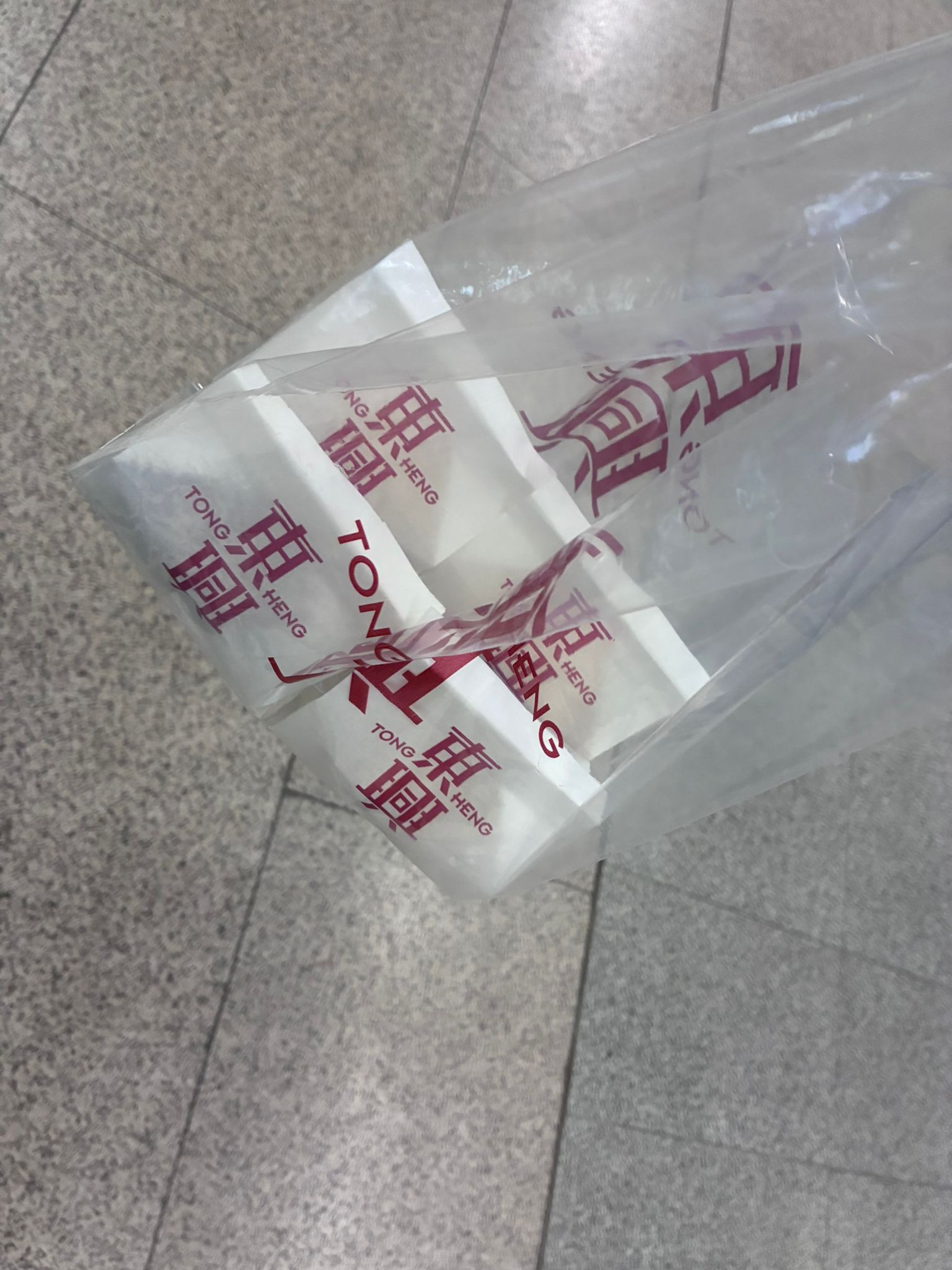 Takeaway paper packets of Tong Heng egg tarts in a plastic bag