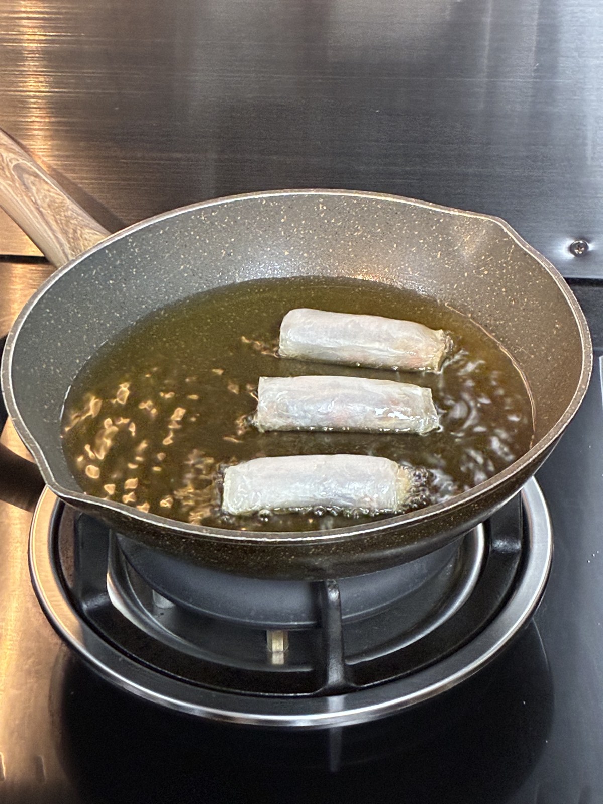 Spring rolls being deep-fried in a pan during a Vietnamese cooking class, Ho Chi Minh City