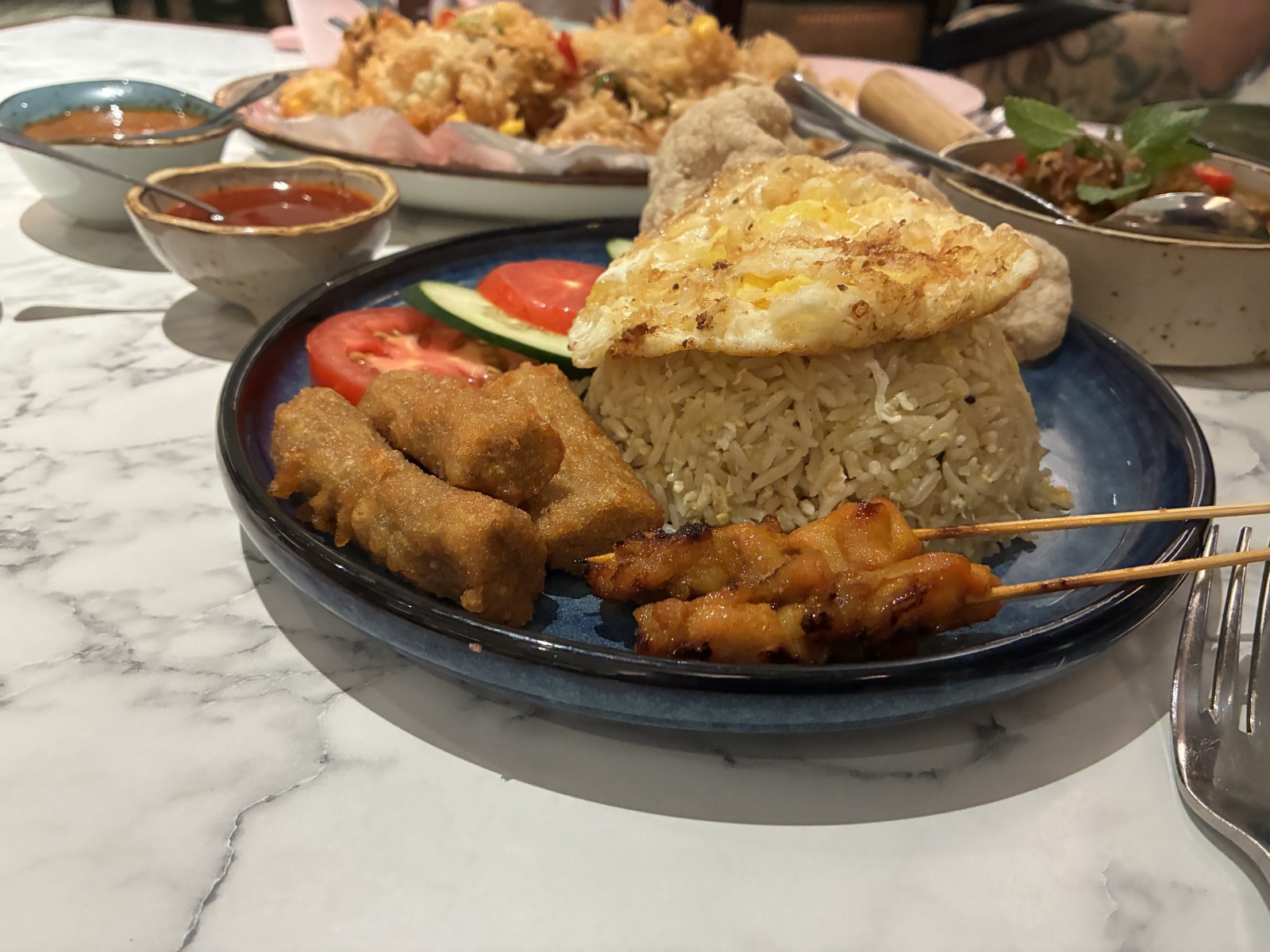 Nasi lemak with fried egg, satay skewers, tempeh, tomato and prawn cracker at De.Wan 1958, Kuala Lumpur