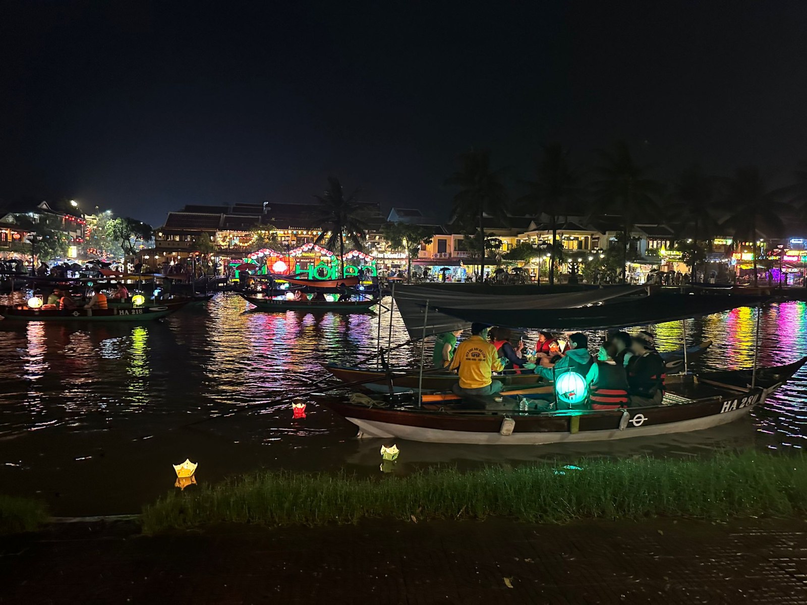 Lantern boats and floating candles on the Thu Bon River at night in Hoi An, Vietnam (faces blurred)