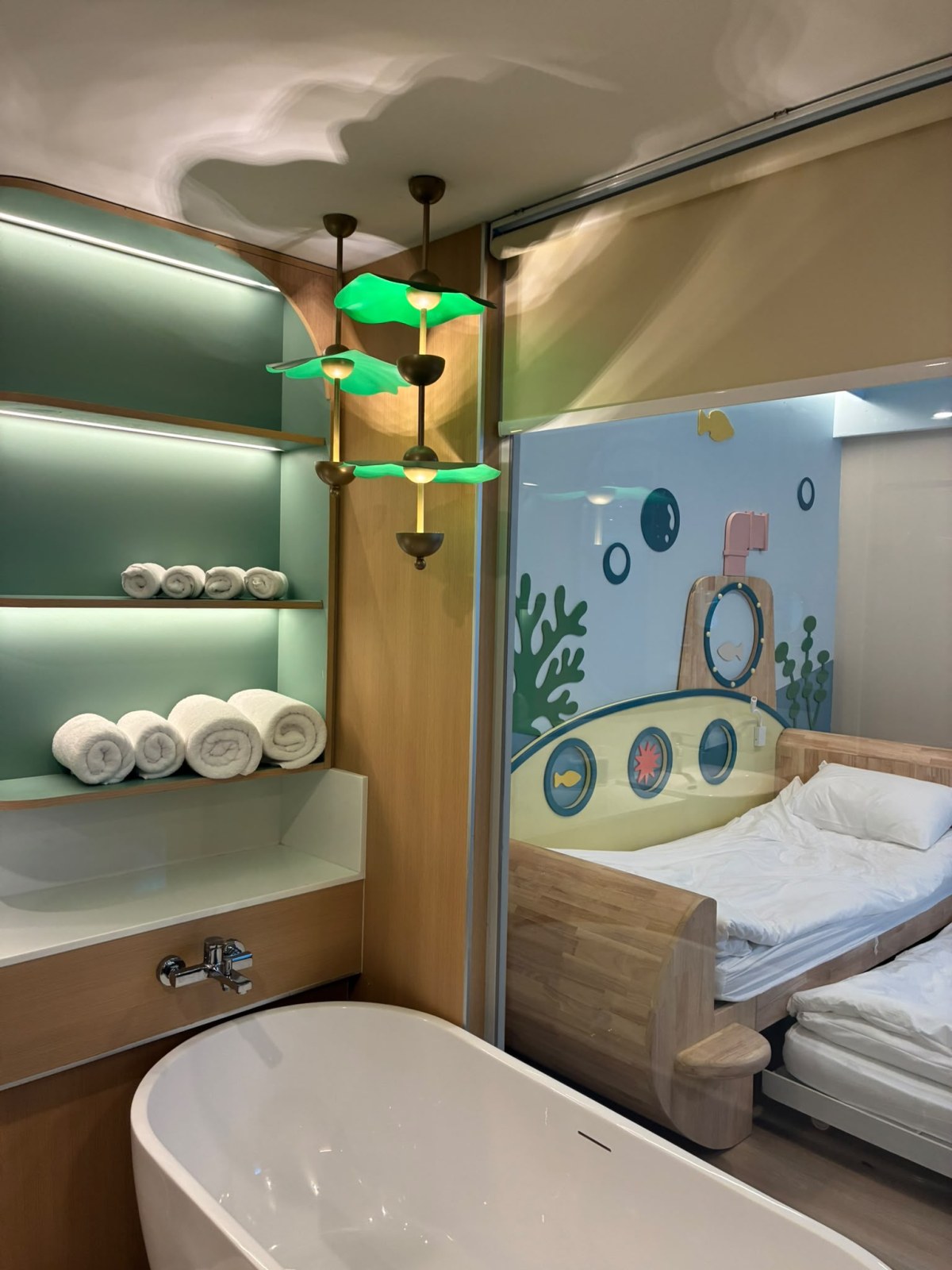 Bathroom with bathtub next to the children's beds in a family room at Katathani Phuket Beach Resort, Thailand