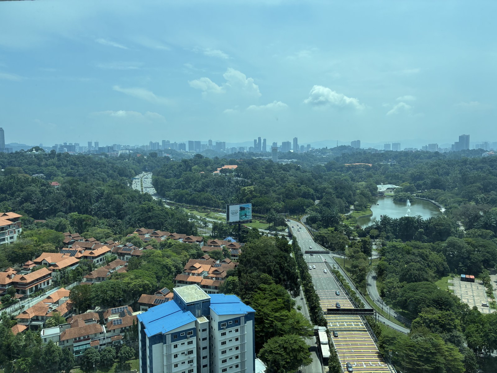 Kuala Lumpur skyline with parkland and lake seen from a high floor, Malaysia