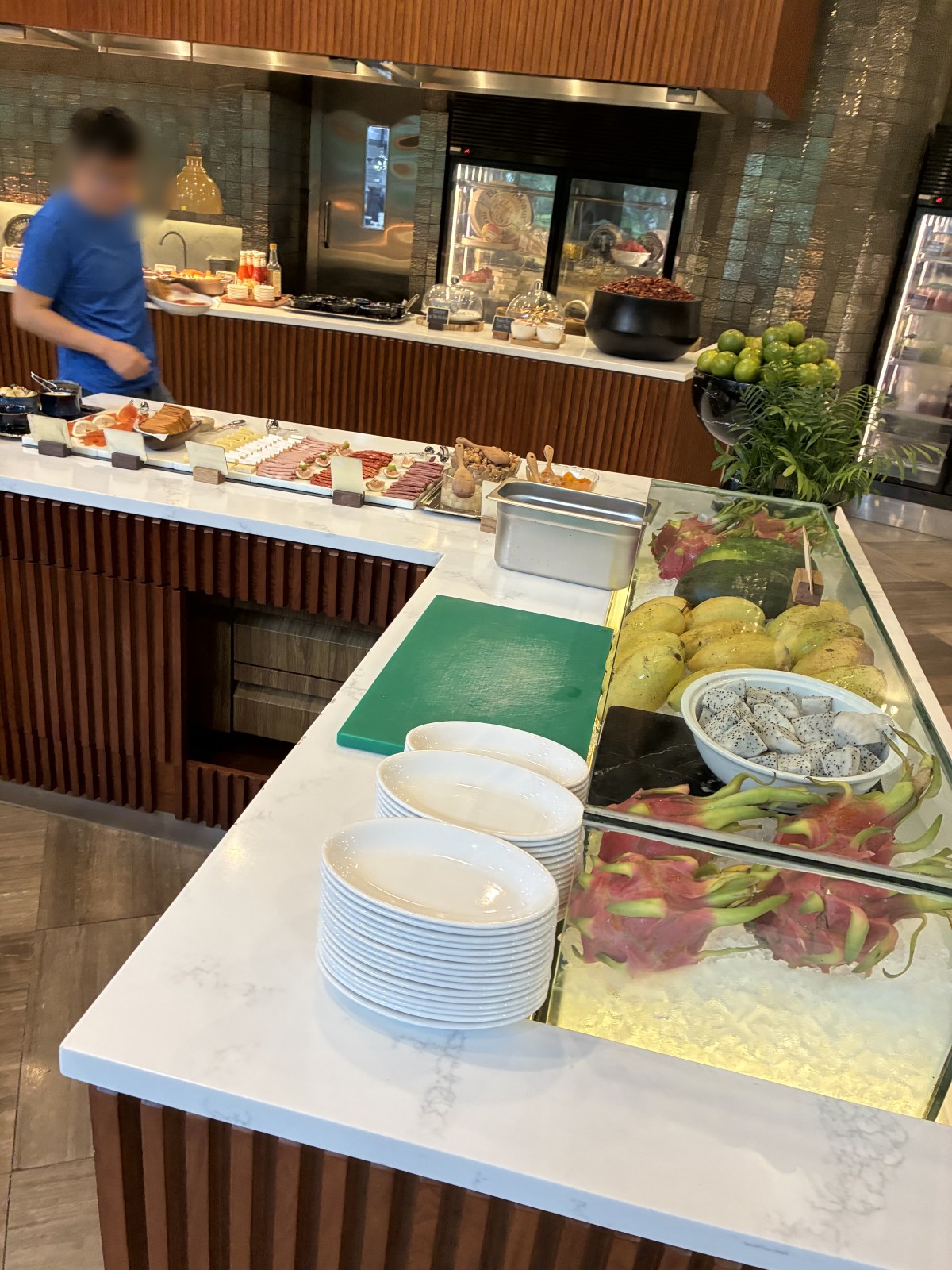 Fresh fruit and cold cuts counter at the New World Saigon Hotel breakfast buffet, Vietnam (faces blurred)