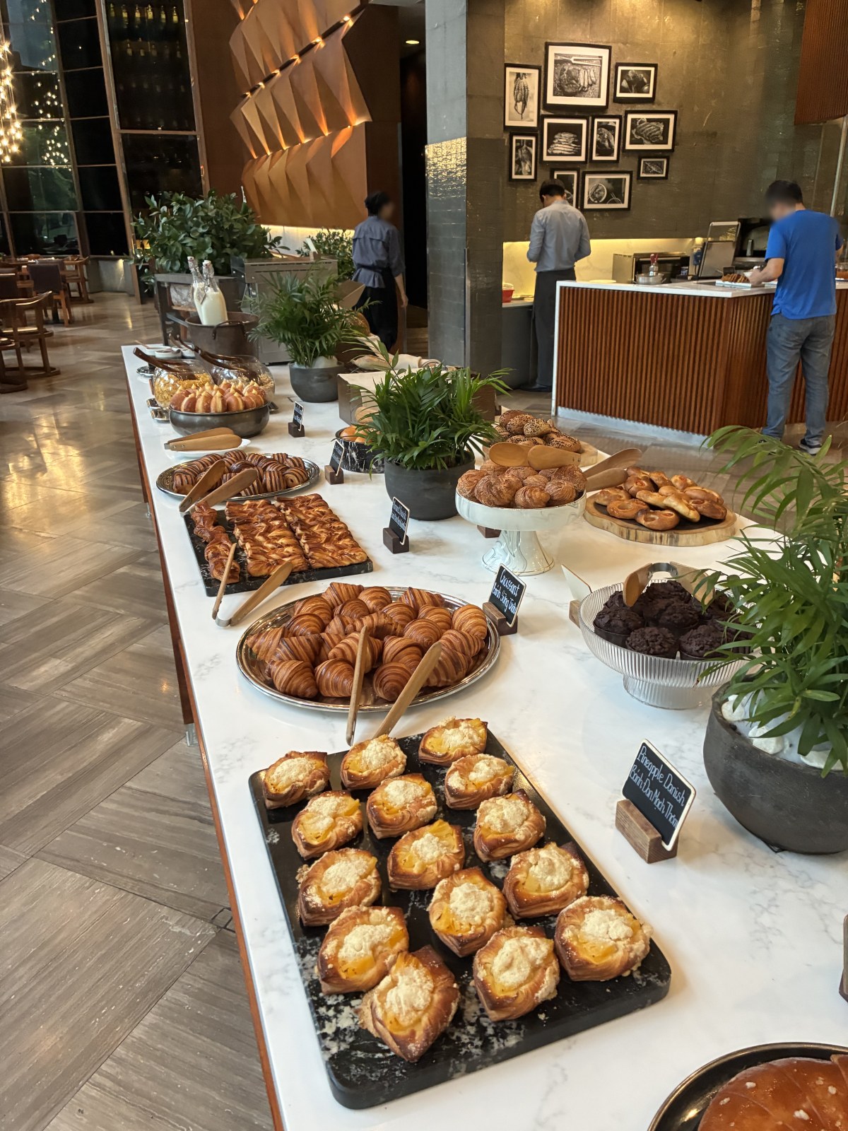 Pastry and bread counter at the breakfast buffet of New World Saigon Hotel, Vietnam (faces blurred)