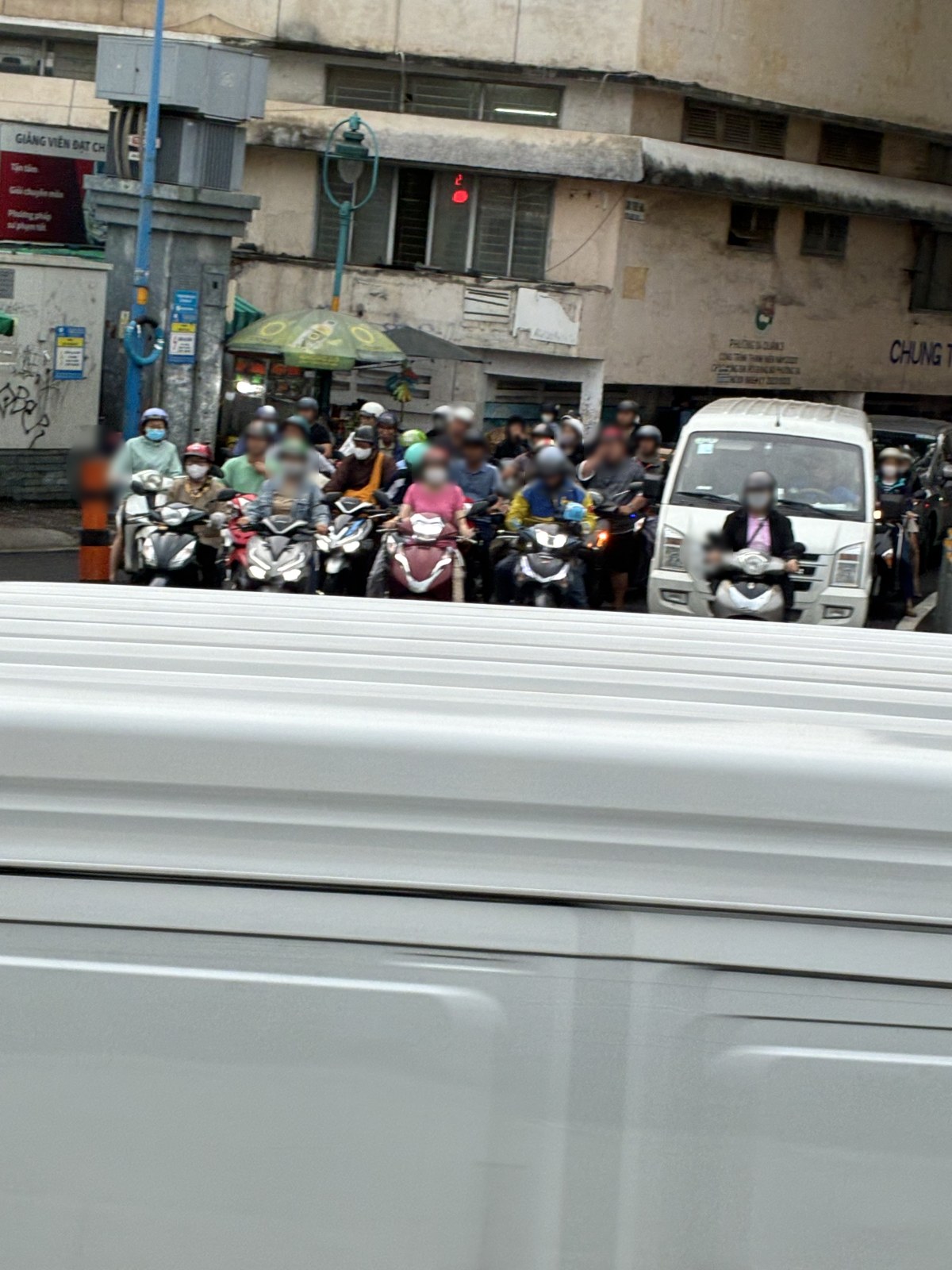Dozens of motorbikes waiting at a traffic light in Ho Chi Minh City, Vietnam (faces blurred)