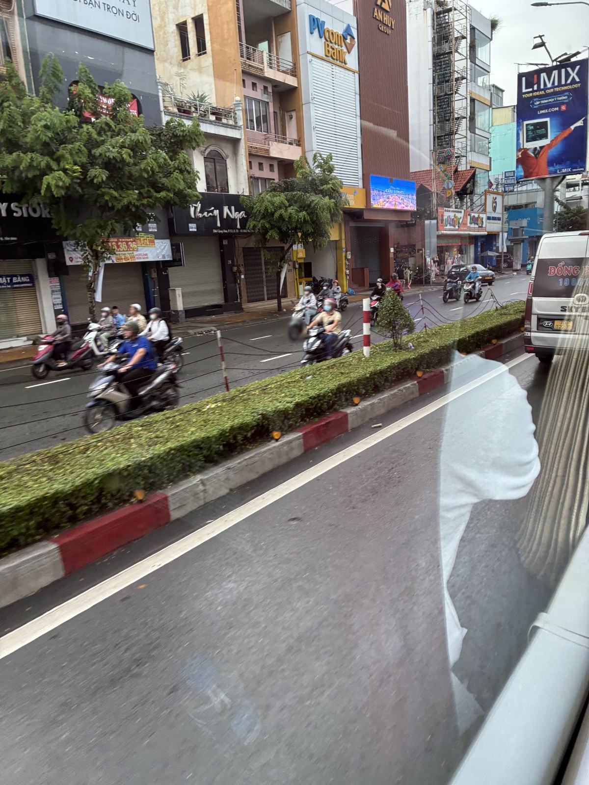 Motorbikes riding along a street in Ho Chi Minh City seen from a bus window, Vietnam (faces blurred)