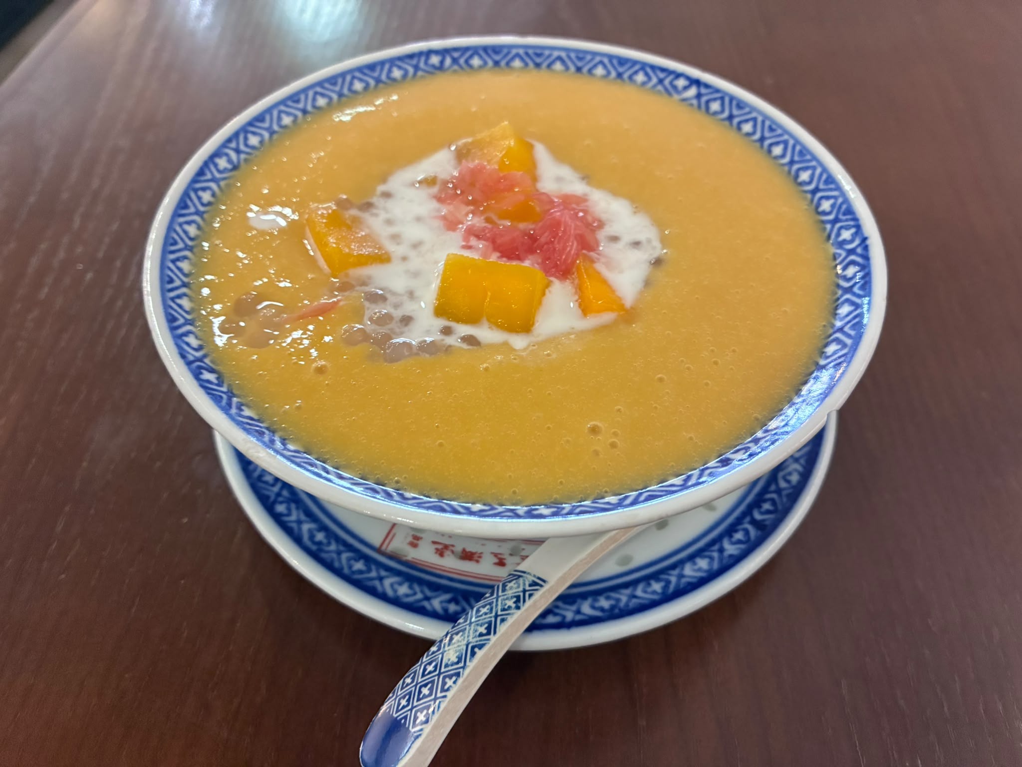 Mango pomelo sago dessert in a blue and white bowl at Jin Yu Man Tang, Singapore