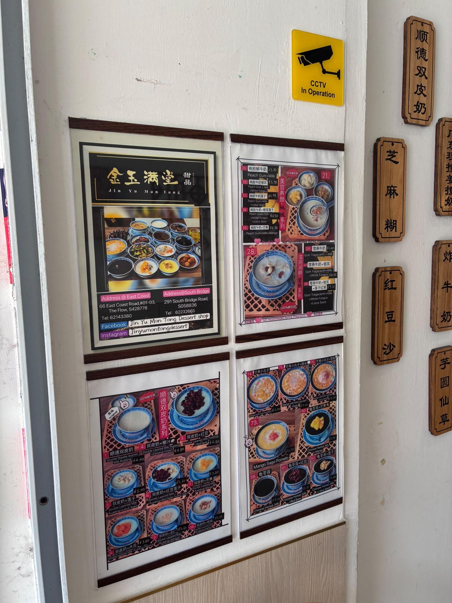 Menu posters and wooden dessert name plaques at Jin Yu Man Tang, Singapore